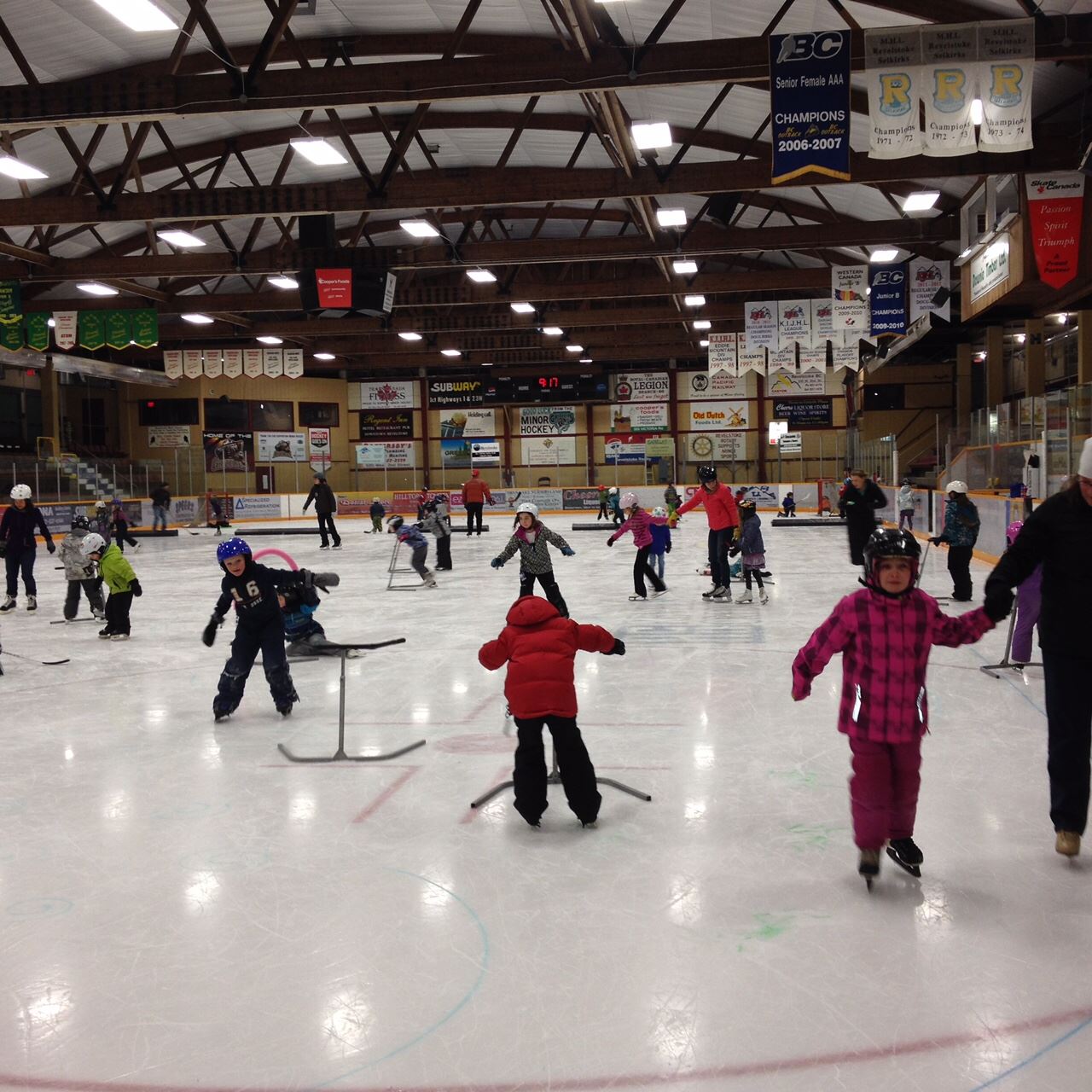 Kids and adults skating in an ice rink